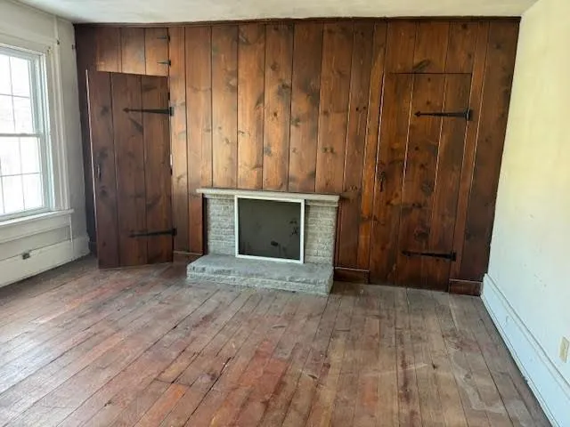 a view of an empty room with wooden floor and a cabinet