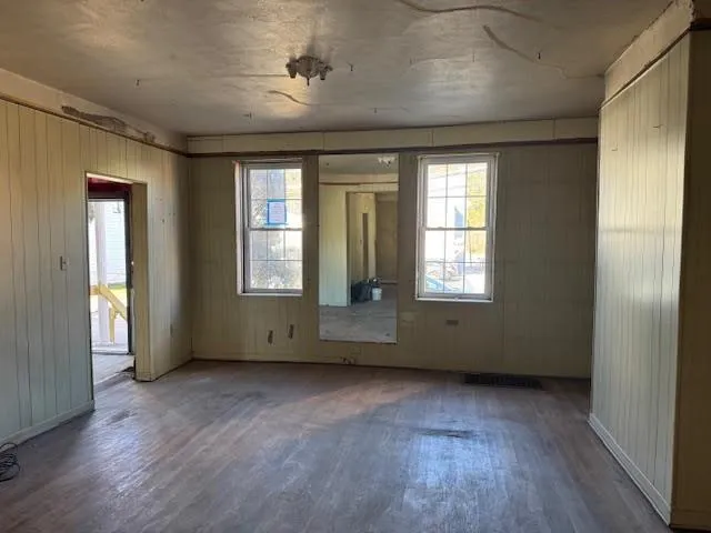 an empty room with wooden floor and windows