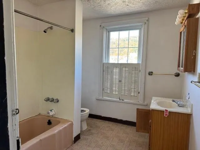 a bathroom with a tub sink and mirror