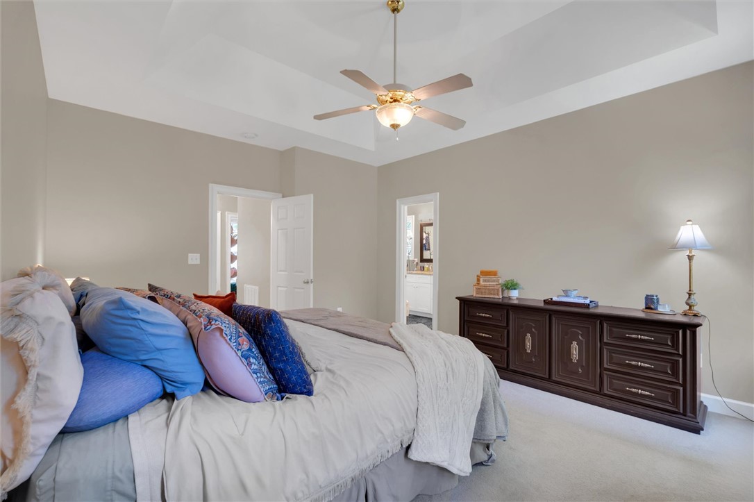 117 Winding Creek Road Anderson, SC 29621 - Photo 18 of 42 This spacious bedroom features a tray ceiling and plush carpeting, offering comfort and style.