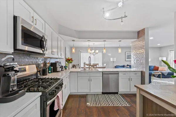 a kitchen with stainless steel appliances granite countertop a stove top oven a sink a counter space and cabinets