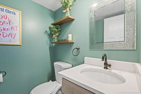 a bathroom with a toilet sink and mirror