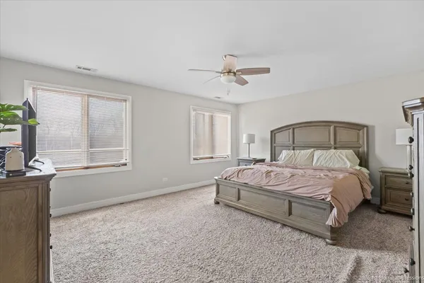a spacious bedroom with a bed chandelier and window