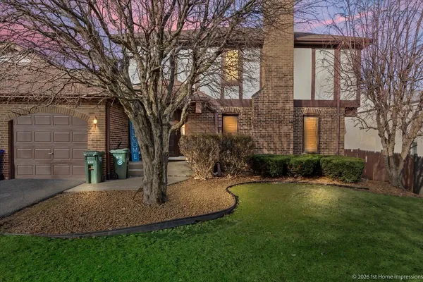 a view of a house with brick walls and a tree