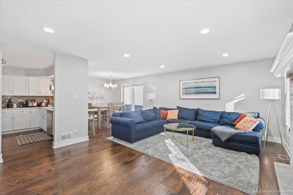 a living room with furniture and a view of kitchen