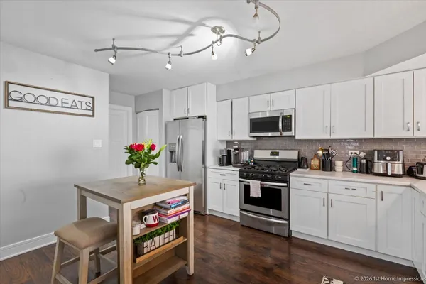 a kitchen with granite countertop stainless steel appliances a stove cabinets and wooden floor