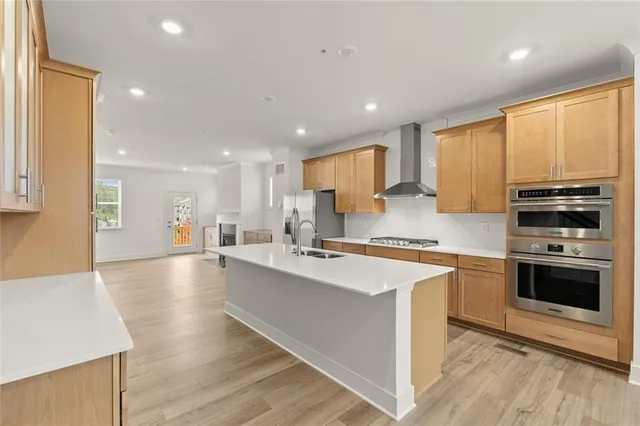 a large kitchen with stainless steel appliances granite countertop a stove a sink and a refrigerator