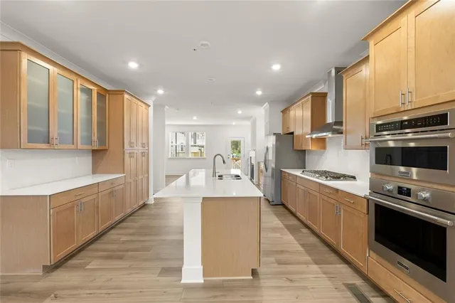 a large kitchen with stainless steel appliances and a large window