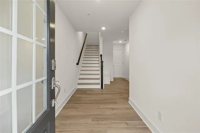 a view of a hallway with wooden floor and entryway