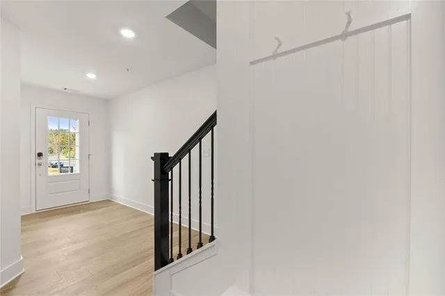 a view of a hallway with wooden floor and stairs