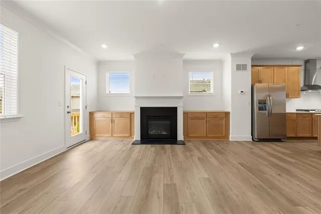 a view of empty room with wooden floor and fireplace