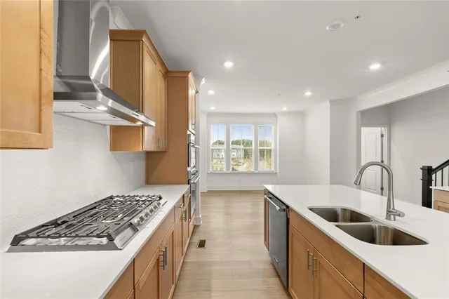 a kitchen with stainless steel appliances granite countertop a sink and a stove