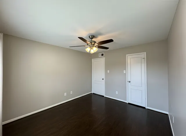 a view of wooden floor and a chandelier fan in a room