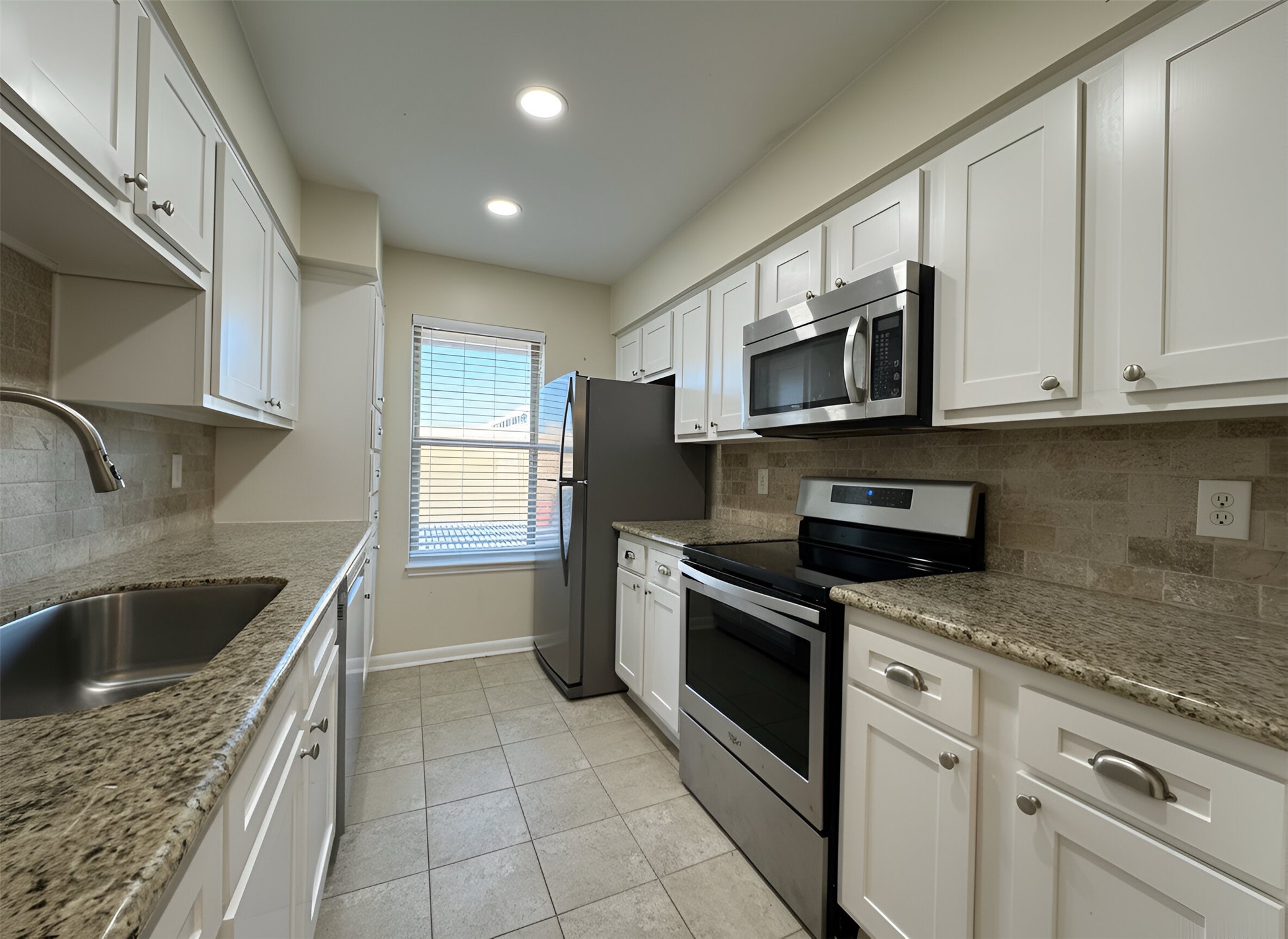 845 Augusta Drive, Unit 90 Houston, TX 77057 - Photo 7 of 17 a kitchen with stainless steel appliances granite countertop a sink and a stove top oven with granite countertops