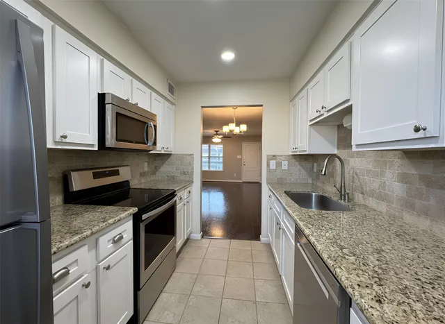 a kitchen with granite countertop a stove and a sink