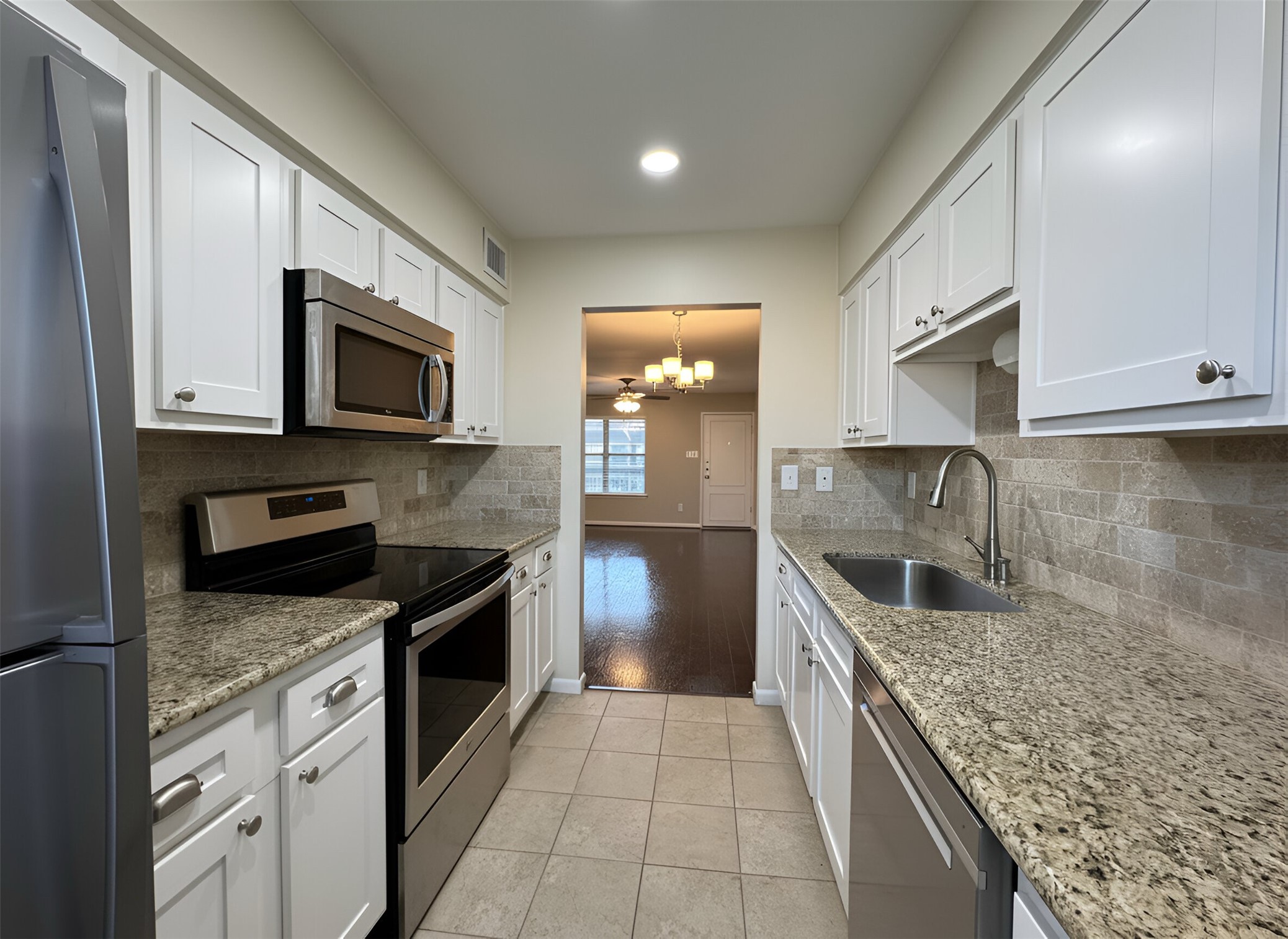 845 Augusta Drive, Unit 90 Houston, TX 77057 - Photo 8 of 17 a kitchen with granite countertop a stove and a sink