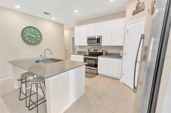 a kitchen with stainless steel appliances a sink a stove a refrigerator and cabinets