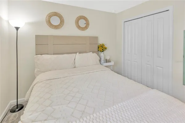 a bedroom with a bed and painting on the wall