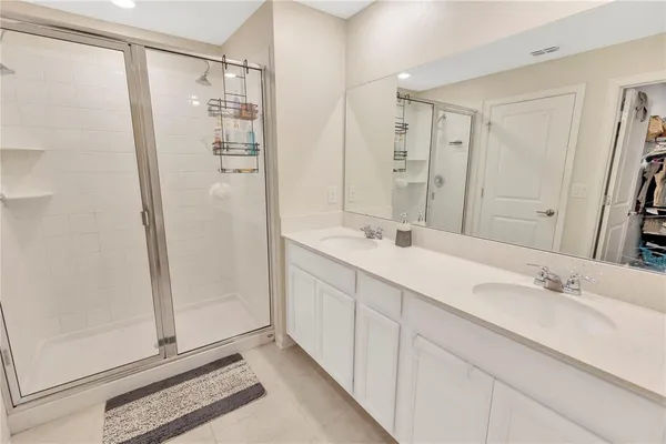 a bathroom with a double vanity sink mirror and shower