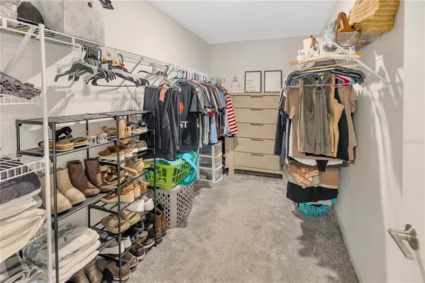 a view of walk in closet with clothes