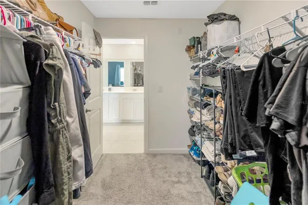 a view of walk in closet with clothes and shoes