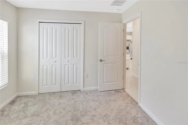an empty room with windows and closet