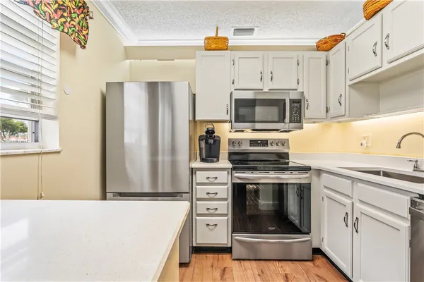 a kitchen with stainless steel appliances a stove a microwave and a refrigerator