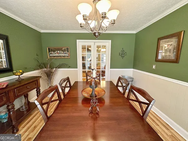 a view of a dining room with furniture wooden floor and a chandelier