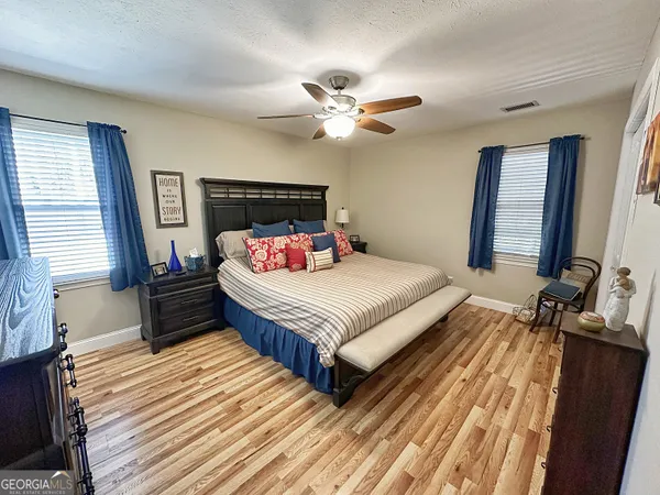 a bedroom with a bed and wooden floor
