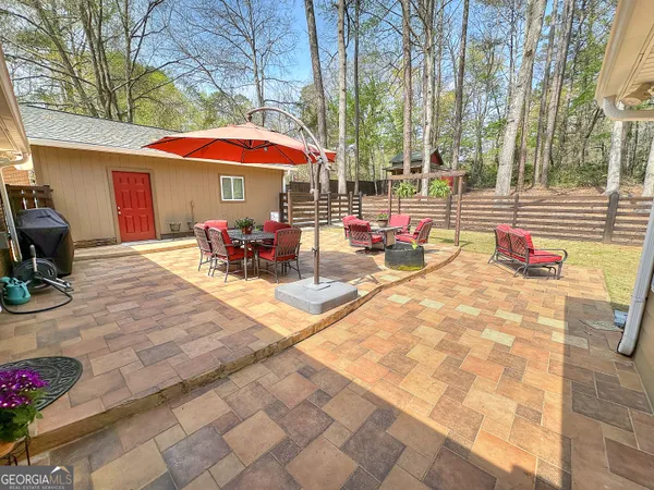 a view of a house with a patio chairs and a table
