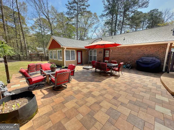 a view of a patio with a table and chairs under an umbrella