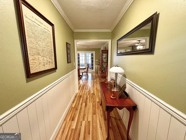 a view of a hallway with furniture and wooden floor