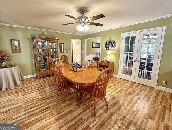 a dining room with wooden floor and large window