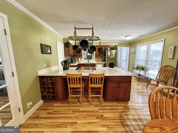 a living room with stainless steel appliances kitchen island granite countertop a table and chairs in it
