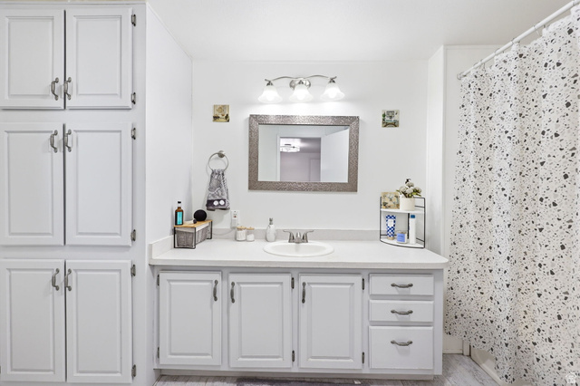 1525 South 400 East, Unit 13 Springville, UT 84663 - Photo 20 of 32 Bathroom featuring a single vanity with a white countertop, under-mount sink, and a framed mirror