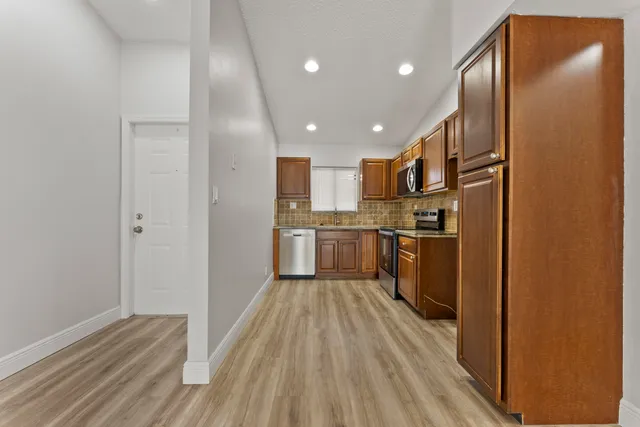 a kitchen with stainless steel appliances granite countertop a refrigerator sink and cabinets