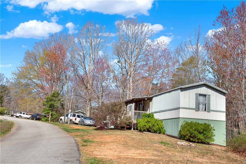 120 Bear Ridge Road Dahlonega, GA 30533 - Photo 3 of 7 a view of a white house with a yard and a large tree