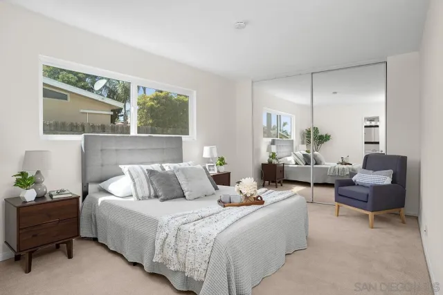 a bedroom with furniture and a large window