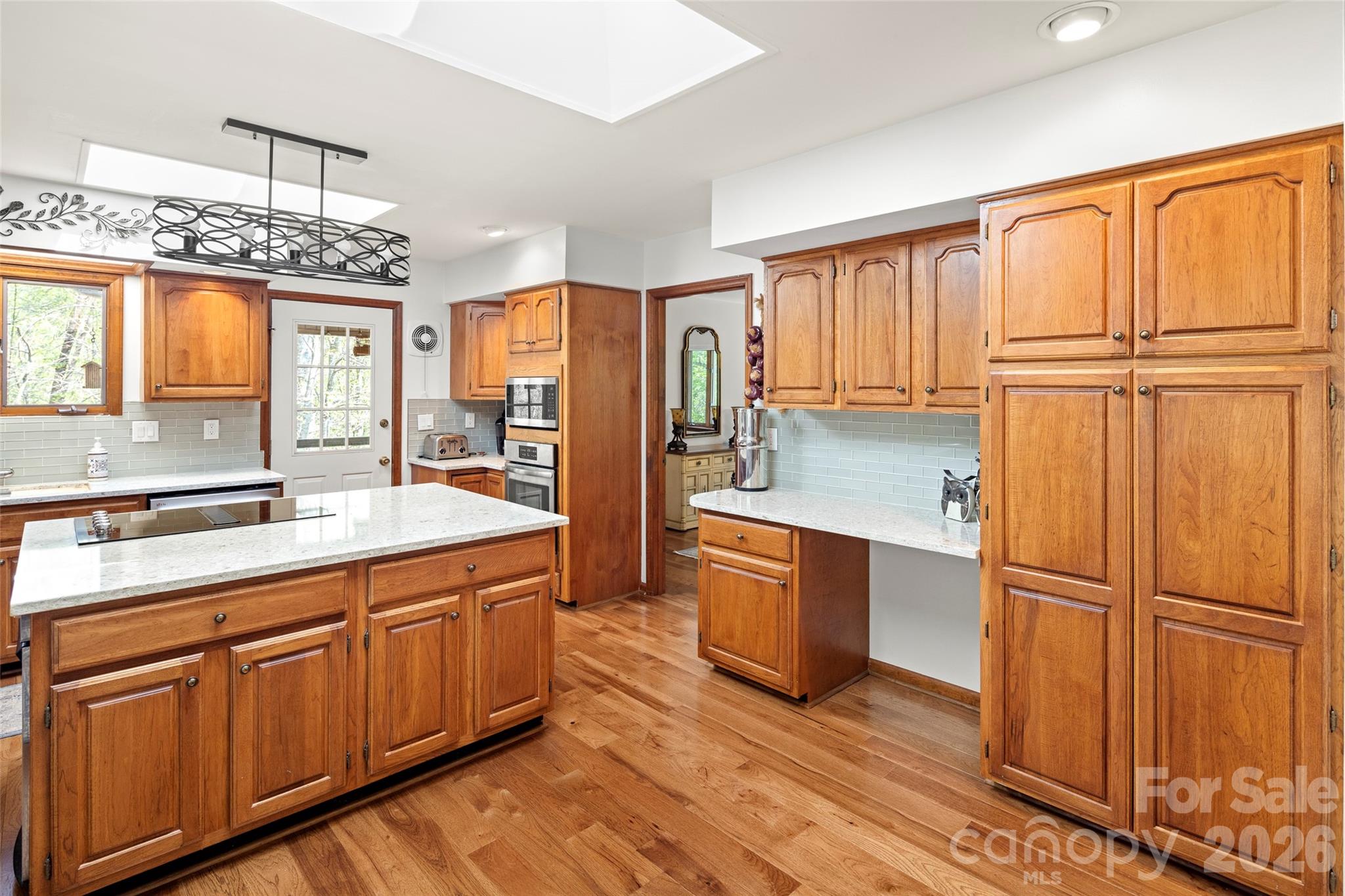 119 Rome Court Lake Lure, NC 28746 - Photo 12 of 31 a kitchen with stainless steel appliances granite countertop a refrigerator oven a sink dishwasher and wooden cabinets with wooden floor
