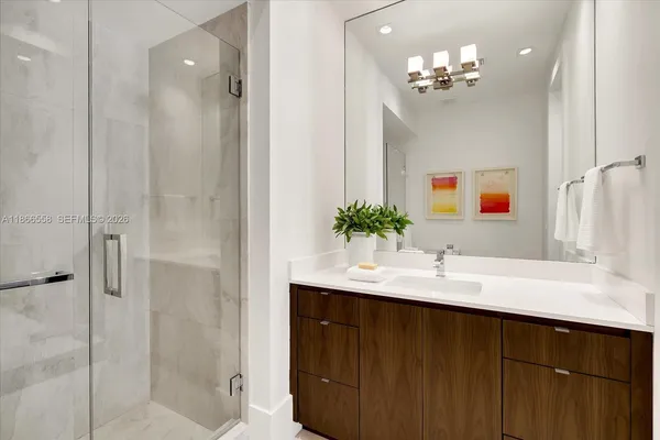 a bathroom with a sink vanity granite shower and a mirror