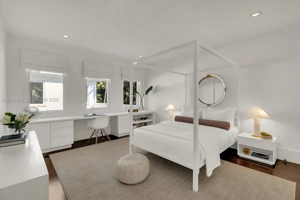 a bedroom with a large bed and wooden floor