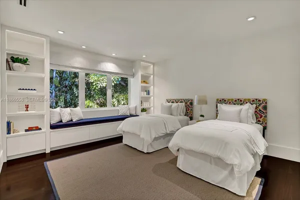 a spacious bedroom with two beds and a large window