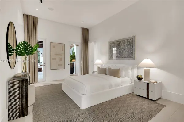 a bedroom with a bed lamps and mirror