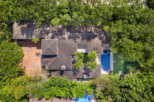 an aerial view of a house with a yard and a large tree