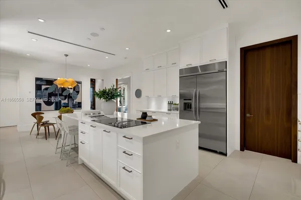 a kitchen with stainless steel appliances kitchen island granite countertop a refrigerator and a sink