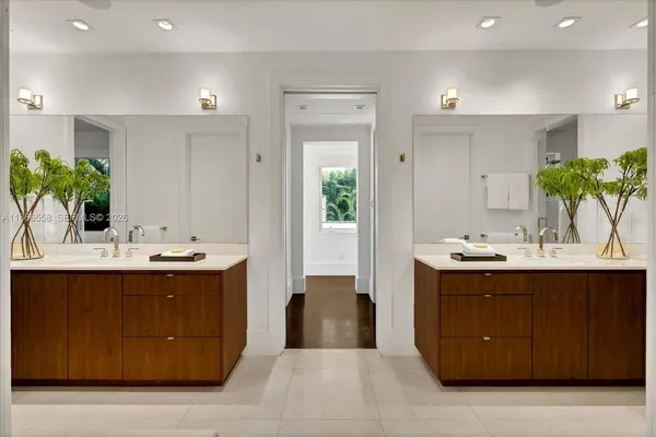 a view with a double vanity sink mirror and cabinets