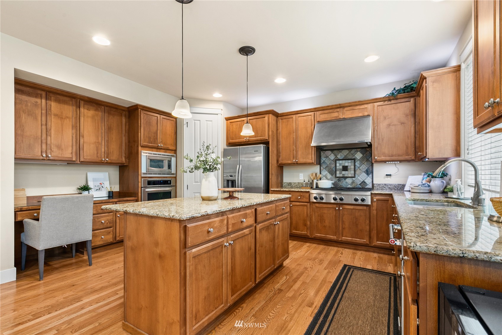 18407 36th Avenue Southeast Bothell, WA 98012 - Photo 7 of 39 a kitchen with stainless steel appliances granite countertop a stove top oven a sink dishwasher a dining table and chairs with wooden floor