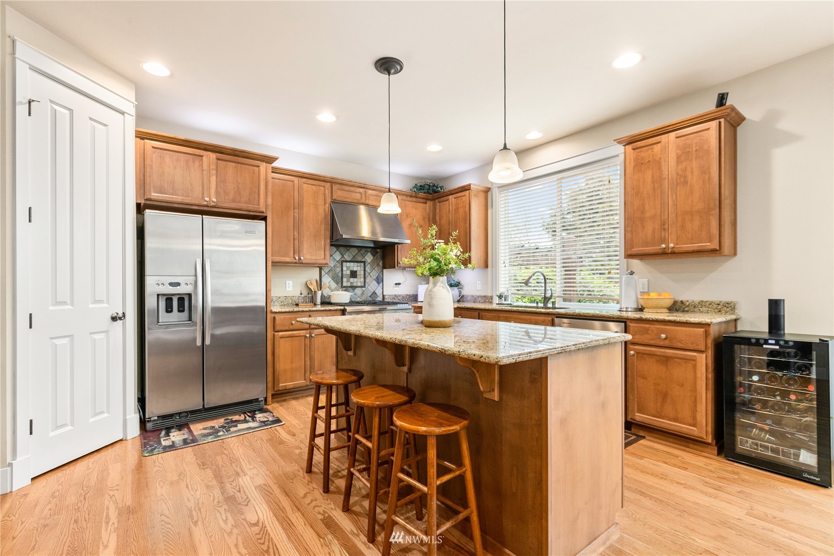 18407 36th Avenue Southeast Bothell, WA 98012 - Photo 8 of 39 a kitchen with stainless steel appliances granite countertop a refrigerator a sink dishwasher a stove and white countertops with wooden floor