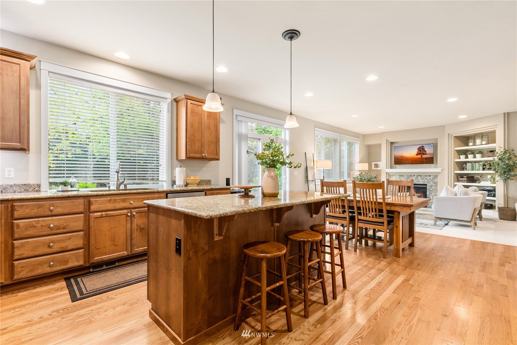 18407 36th Avenue Southeast Bothell, WA 98012 - Photo 9 of 39 a open kitchen with stainless steel appliances granite countertop a stove top oven a dining table and chairs with wooden floor