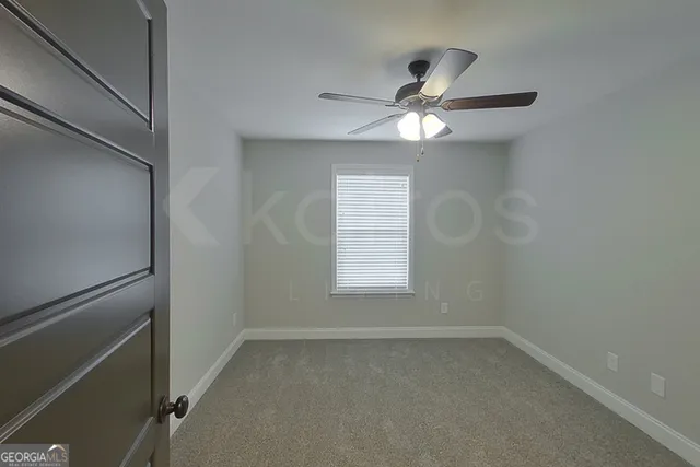 an empty room with a window and a fan